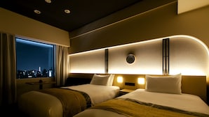 A hotel room with two beds, a large window, and a city view.