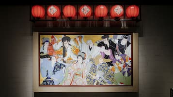 Una obra de arte japonesa tradicional con una presentación enmarco, iluminada por faroles rojos.