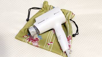 Un sèche-cheveux Panasonic posé sur un tissu à motifs floraux.
