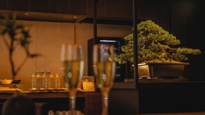 A dining area with a bonsai tree, a glass table, and a modern interior design. - Hotel Gracery Kyoto Sanjo (Kyoto)