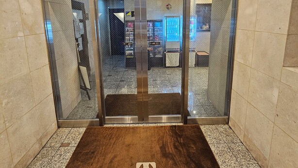An elevator entrance with a brown floor mat and a sign in Japanese. - Kuretake Inn Tokyo Funabori (Tokyo)