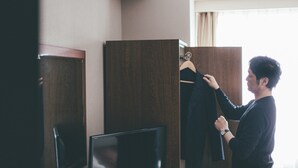A hotel room with a wooden wardrobe, a mirror, and a television. - Kuretake Inn Tokyo Funabori (Tokyo)