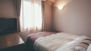 A hotel room with a bed, a TV, a window with curtains, and a wall-mounted light. - Kuretake Inn Tokyo Funabori (Tokyo)
