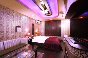 A hotel room with a bed, a sofa, a TV, and a minibar. - Hotel Ohirune Racco Sakai - Adults Only (Sakai)