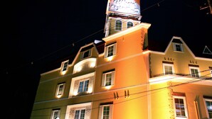 Um edifício de vários andares com uma placa grande no topo.