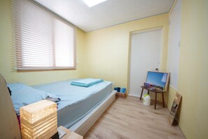 A small, well-lit room with a single bed, a desk, a chair, a window with blinds, and a door. - Pedro's House - Hostel (Gwangju)