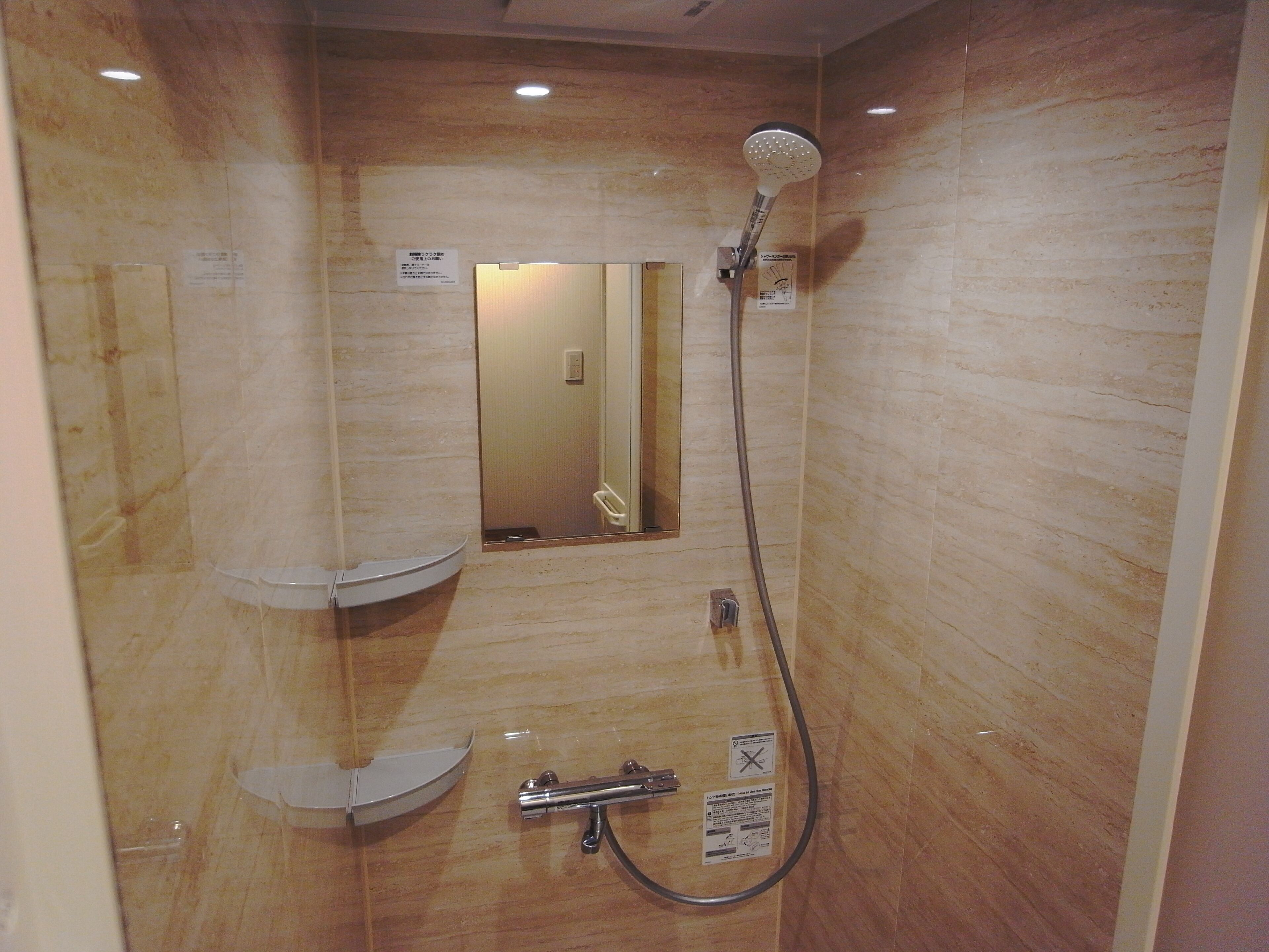 Une salle de bain avec douche, toilettes et lavabo.