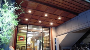 A building entrance with a wooden ceiling, glass doors, and a bicycle parked outside. - Ryokan Yamamuro (Kanazawa)
