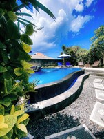 Una piscina al aire libre, sillones reclinables de piscina