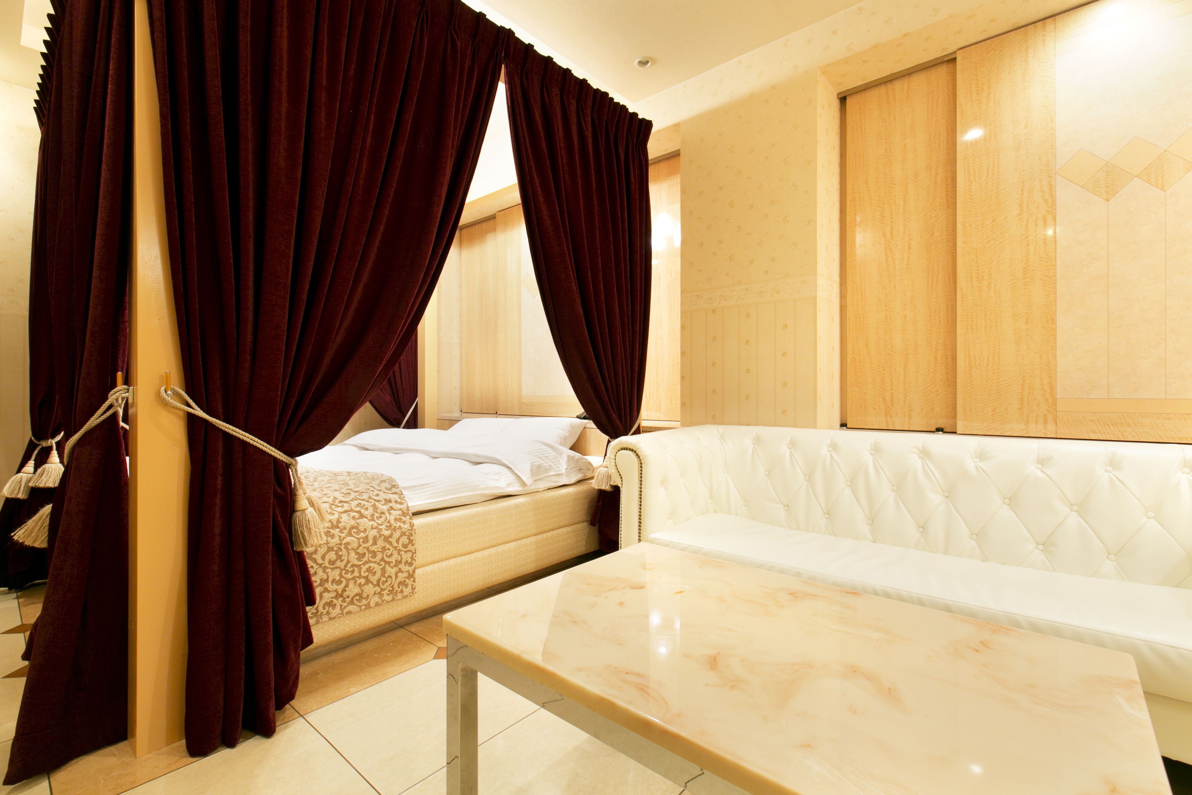 Habitación de hotel con cama, sofá y mesa de mármol.