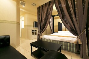 A hotel room with a bed, a black table, and a TV. - Hotel Luna Sennan - Adults Only (Sennan)