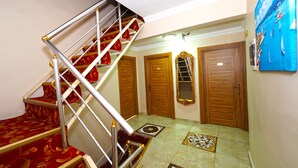 A staircase with red carpeted steps, a metal railing, and wooden doors. - Seyri Istanbul Hotel (Istanbul)
