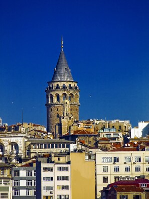 Standing tall amidst the urban landscape, this historic tower boasts multiple levels with arched windows and a central dome.