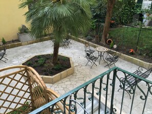 A courtyard with a palm tree, a small garden, and outdoor furniture. - Domus Terenzio (Rome)