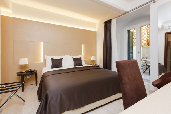 Habitación doble superior, balcón, vista al jardín | Edredón, minibar, caja de seguridad en la habitación y escritorio