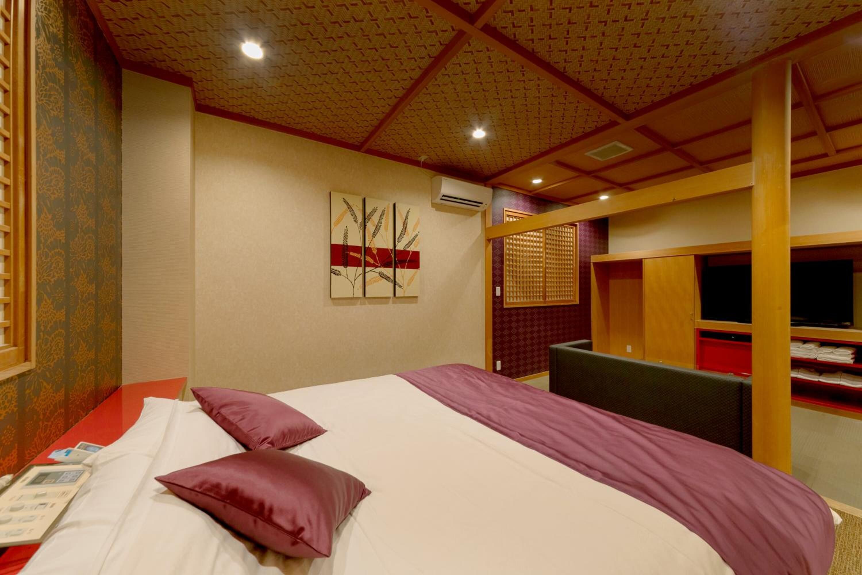 A hotel room with a large bed, a desk, and a TV.
