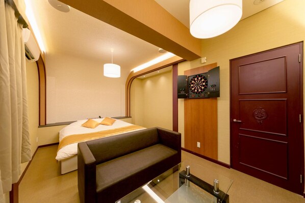 Una habitación de hotel con cama, sofá, dardo y armario.