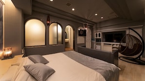 A modern hotel room with a large bed, a hanging chair, and a TV in the corner. - Hotel Lotus Sakai - Adults Only (Sakai)