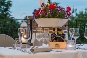 A table set for dining with wine glasses, bottles, and a candle. - Agriturismo Acetaia Sereni (Marano sul Panaro)