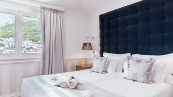 Una habitación de hotel con una cama grande, vistas a la ciudad y una ventana con cortinas.