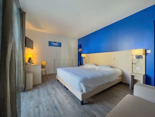 Una habitación de hotel moderna con una cama grande, un escritorio y una silla.