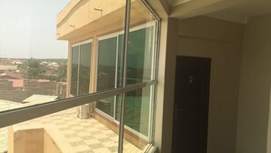 Ein Balkon mit großen Fenstern mit Blick auf eine Wohngegend.