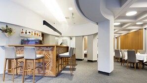 A modern hotel lobby with a reception desk, bar area, and seating arrangements. - Orasac Garni (Belgrade)