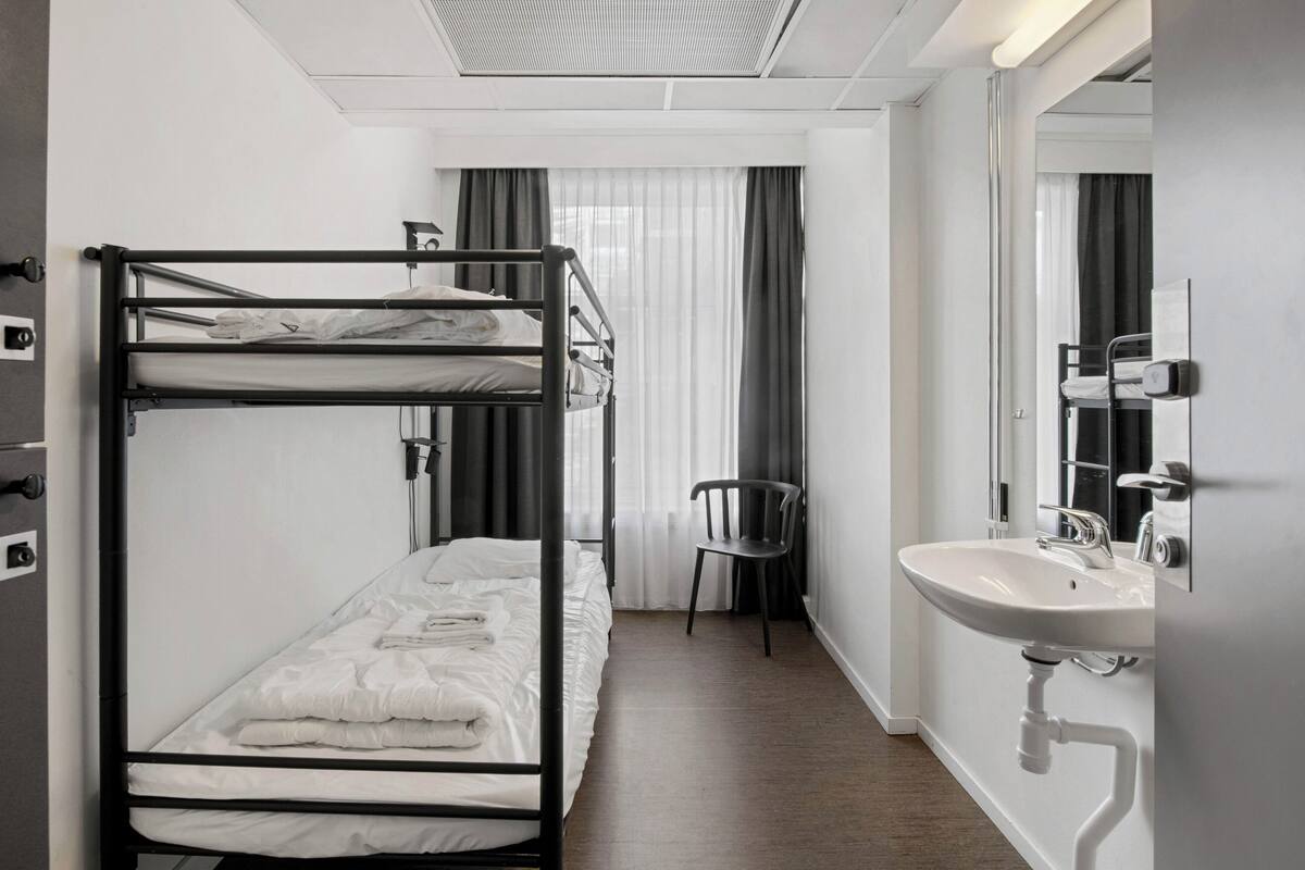 Quarto com beliche, pia e cadeira.