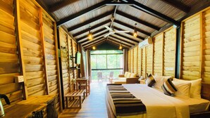 Una habitación tipo cabaña de madera con una cama, un escritorio y una silla.