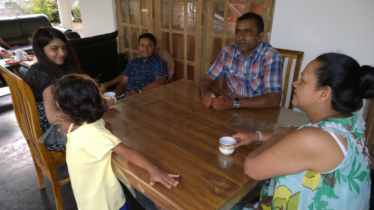 A group of people seated around a wooden table in a room with a simple, clean design.