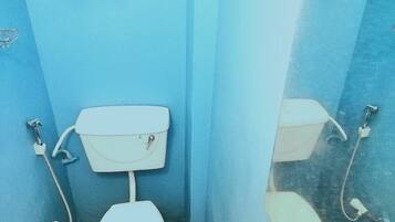 A small, enclosed bathroom with a white toilet and a wall-mounted tank.