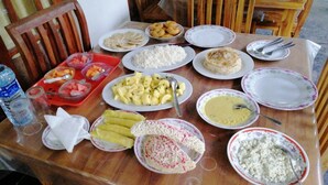 Una mesa de comedor con diversos platos, incluyendo arroz, fruta y pan.