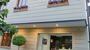 A two-story building with a reception desk, a small tree in front, and flower boxes on the windowsills. - My Hotel Yerevan (Yerevan)