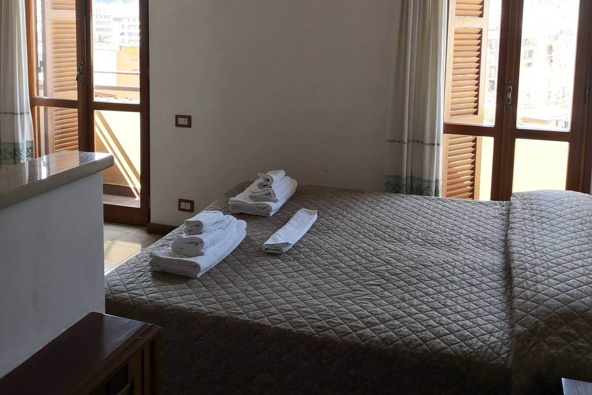 Una camera d'albergo con un letto, una scrivania e un condizionatore d'aria.