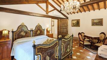 Un dormitorio con una cama grande y elaborada, muebles de madera y un candelabro.