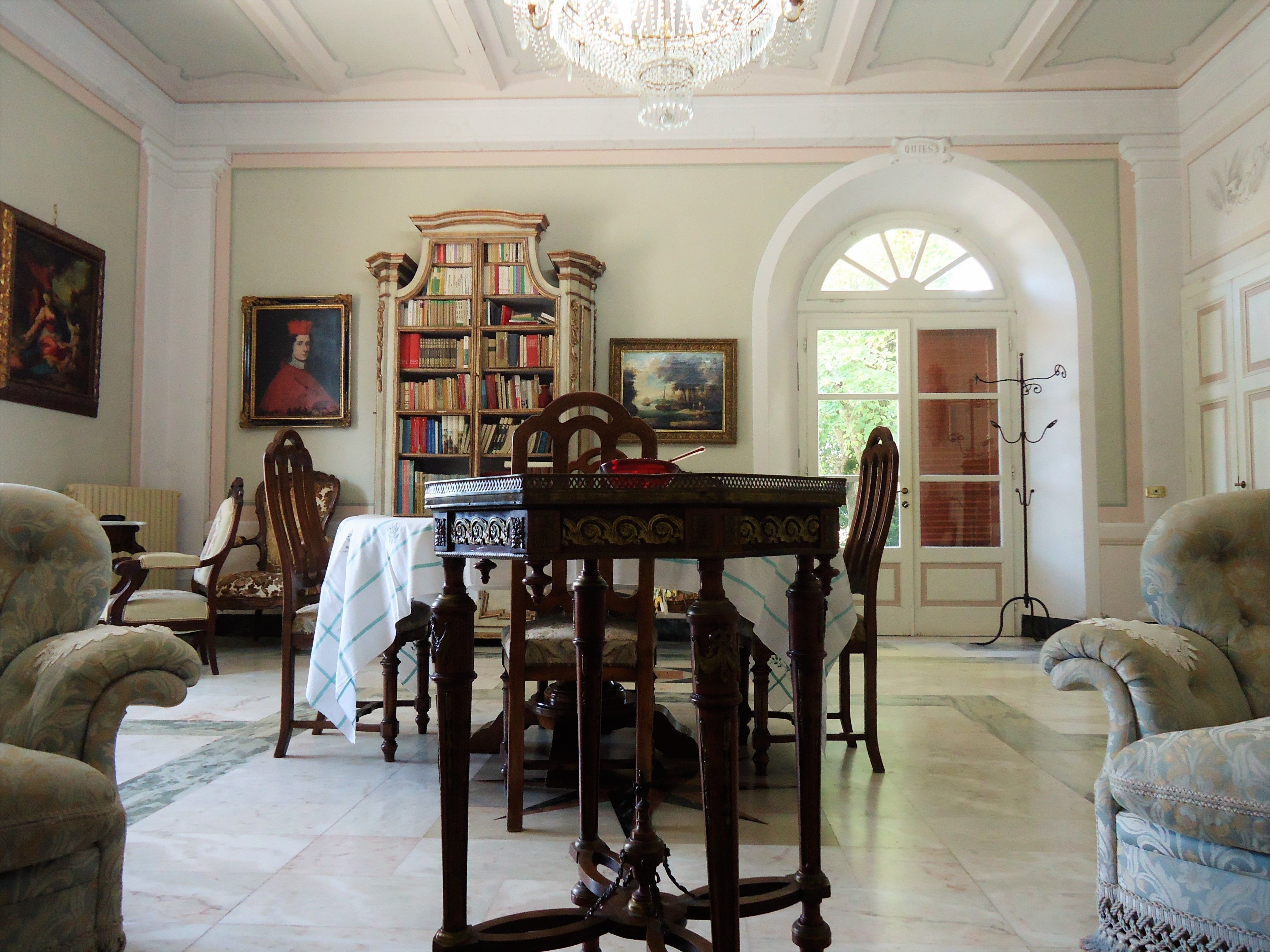 Uma sala de jantar formal com mesa de madeira, cadeiras e estante.