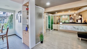 A modern reception area with a marble counter, a reception desk, and a glass partition. - Fun-D City View (Khon Kaen)