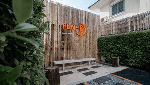 A bamboo fence with a bench and a wooden stump. - Fun-D City View (Khon Kaen)