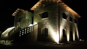 Vista frontal de la propiedad por la tarde o noche