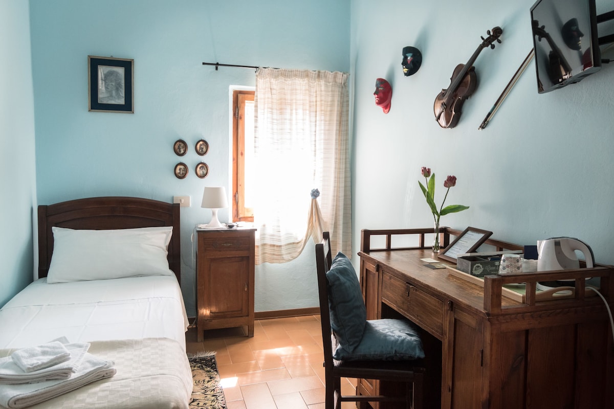 Une chambre à coucher comprenant un lit, une table de chevet et un bureau avec une chaise.