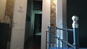 A room with a wooden ceiling, a stone wall, and a door labeled "Stanza del cacciatore". - Tananei (Marliana)