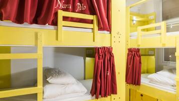 A bunk bed room with yellow beds and red curtains.