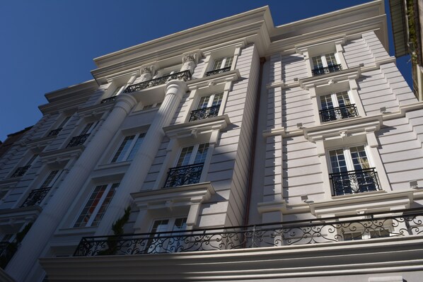 A multi-story building with classical architecture, featuring columns, balconies, and large windows. - Lot Boutique Hotel (Tirana)