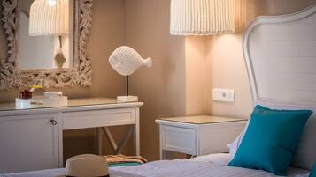 Une chambre à coucher bien rangée, avec un lit, des tables de chevet, une commode, un miroir et une lampe.