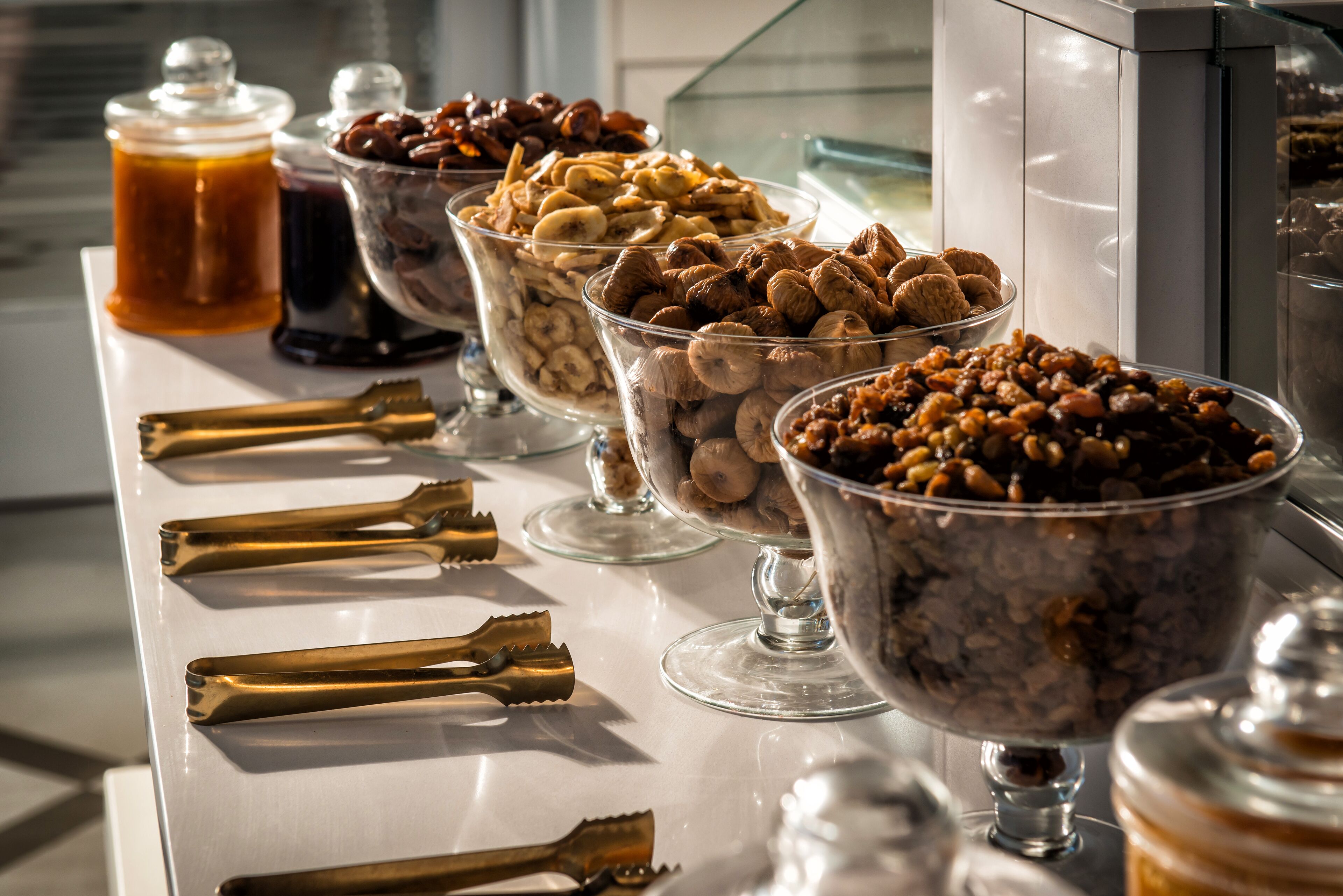 A buffet table with various food items and condiments.