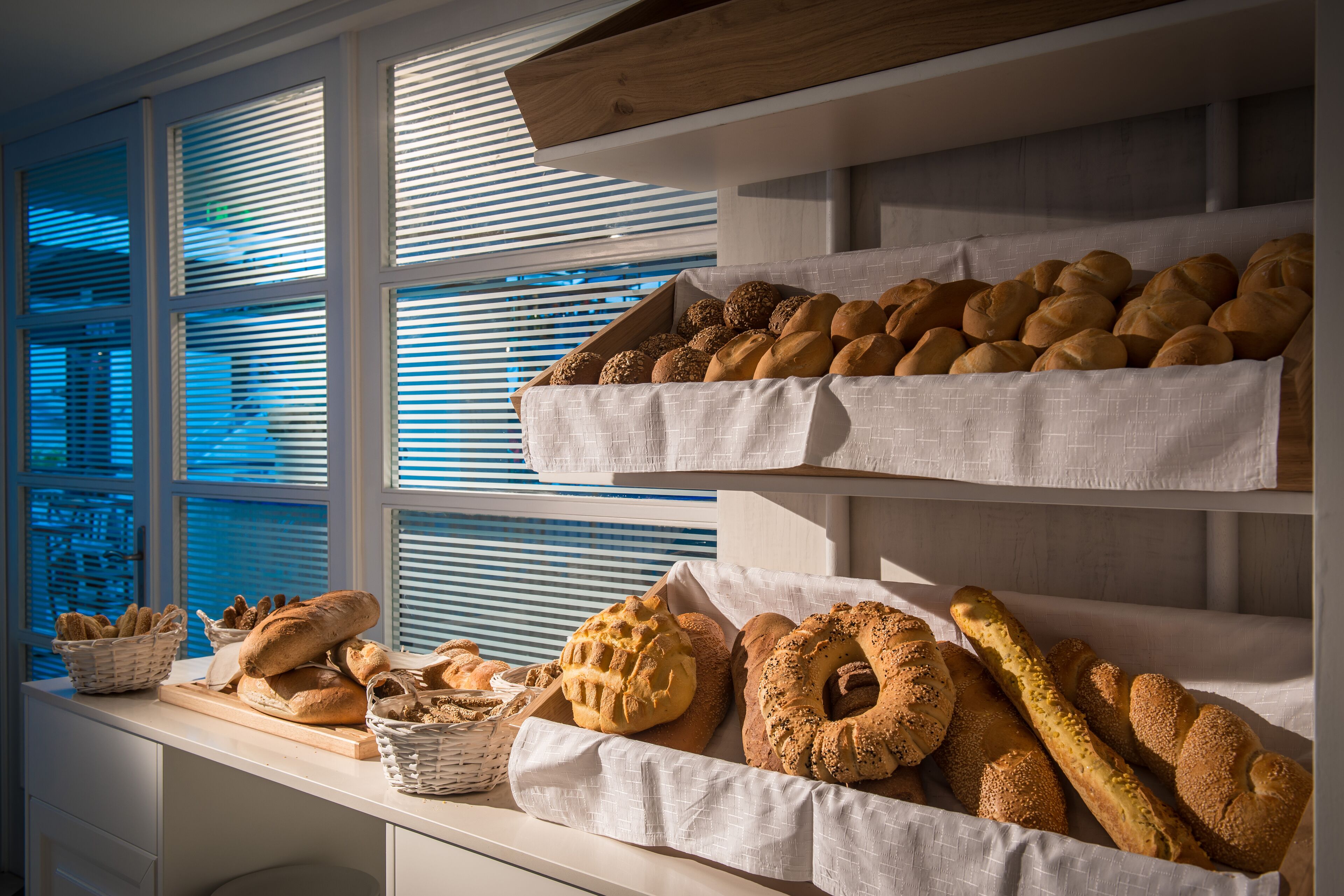 A bakery display with various breads and pastries.