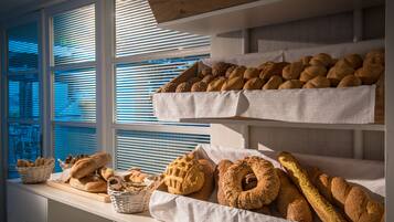 A bakery display with various breads and pastries.