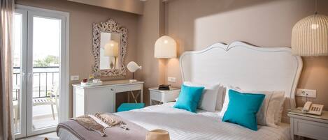 A hotel room with a large bed, a desk, a chair, a mirror, and a balcony.