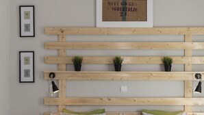 Una habitación con un revestimiento de listones de madera, una lámpara colgante y cuadros enmarcados.