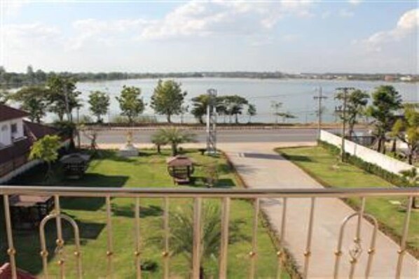 A residential area with a view of a body of water, a paved pathway, and a small garden with a gazebo.